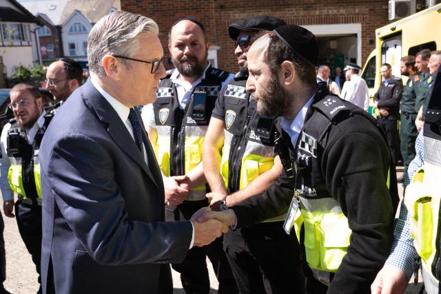 Britain's Prime Minister Keir Starmer (L) meets first responders from Shomrim North West London during a visit to Golders Green in north-west London on April 30, 2026, the day after two men were stabbed. Two Jewish men were wounded in stabbings in north London on April 29, investigated by police in the British capital as a "terrorist incident", after a series of antisemitic attacks in recent weeks. (Photo by Stefan Rousseau / POOL / AFP)