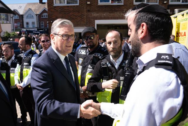 Britain's Prime Minister Keir Starmer (L) meets first responders from Shomrim North West London during a visit to Golders Green in north-west London on April 30, 2026, the day after two men were stabbed. Two Jewish men were wounded in stabbings in north London on April 29, investigated by police in the British capital as a "terrorist incident", after a series of antisemitic attacks in recent weeks. (Photo by Stefan Rousseau / POOL / AFP)