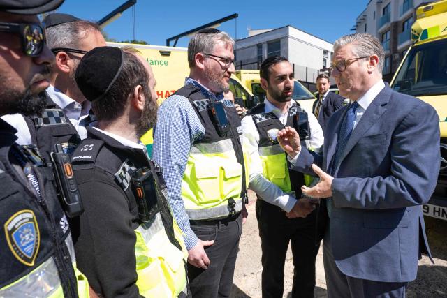 Britain's Prime Minister Keir Starmer (R) meets first responders from Shomrim North West London during a visit to Golders Green in north-west London on April 30, 2026, the day after two men were stabbed. Two Jewish men were wounded in stabbings in north London on April 29, investigated by police in the British capital as a "terrorist incident", after a series of antisemitic attacks in recent weeks. (Photo by Stefan Rousseau / POOL / AFP)