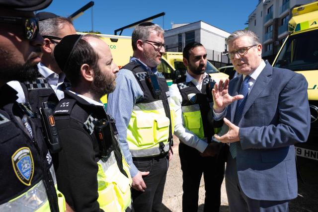 Britain's Prime Minister Keir Starmer (R) meets first responders from Shomrim North West London during a visit to Golders Green in north-west London on April 30, 2026, the day after two men were stabbed. Two Jewish men were wounded in stabbings in north London on April 29, investigated by police in the British capital as a "terrorist incident", after a series of antisemitic attacks in recent weeks. (Photo by Stefan Rousseau / POOL / AFP)