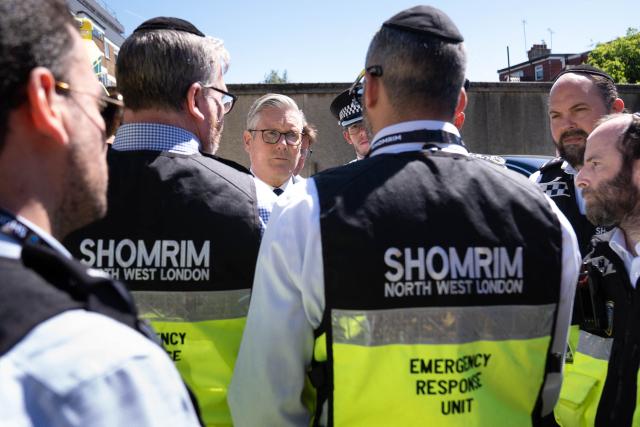 Britain's Prime Minister Keir Starmer (C) meets first responders from Shomrim North West London during a visit to Golders Green in north-west London on April 30, 2026, the day after two men were stabbed. The UK government on April 30 announced extra money for security patrols outside synagogues and schools as community leaders accused it of failing to protect them, a day after the latest attack targeting the Jewish community. (Photo by Stefan Rousseau / POOL / AFP)