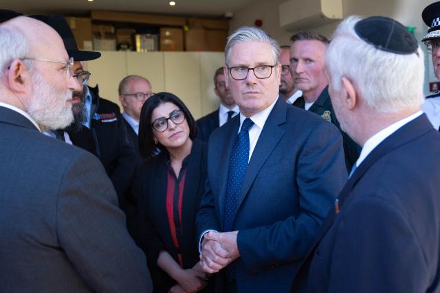 Britain's Prime Minister Keir Starmer (centre R) and Britain's Home Secretary Shabana Mahmood (centre L) meet with members of the Jewish community during a visit to Golders Green in north-west London on April 30, 2026, the day after two men were stabbed. The UK government on April 30 announced extra money for security patrols outside synagogues and schools as community leaders accused it of failing to protect them, a day after the latest attack targeting the Jewish community. (Photo by Stefan Rousseau / POOL / AFP)