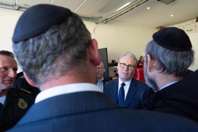 Britain's Prime Minister Keir Starmer (C) speaks with members of the Jewish community during a visit to Golders Green in north-west London on April 30, 2026, the day after two men were stabbed. The UK government on April 30 announced extra money for security patrols outside synagogues and schools as community leaders accused it of failing to protect them, a day after the latest attack targeting the Jewish community. (Photo by Stefan Rousseau / POOL / AFP)