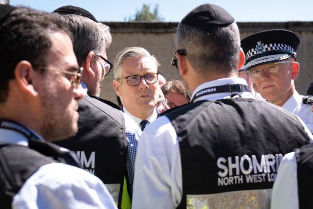 Britain's Prime Minister Keir Starmer (C) and Metropolitan Police Commissioner Mark Rowley (R) meet first responders from Shomrim North West London during. Two Jewish men were wounded in stabbings in north London on April 29, investigated by police in the British capital as a "terrorist incident", after a series of antisemitic attacks in recent weeks. (Photo by Stefan Rousseau / POOL / AFP)