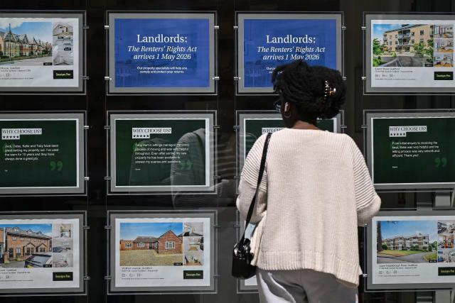 A woman looks at property listings posted in the window of an estate agent in Guildford, south of London on April 30, 2026. The Bank of England on April 30 left its benchmark interest rate unchanged at 3.75 percent, but signalled hikes could be needed if the Middle East war continues to drive up inflation. (Photo by JUSTIN TALLIS / AFP)