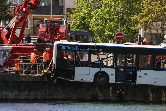 Towing teams remove a bus from the Seine river after it fell with passengers on board into the river, in Juvisy-sur-Orge, on the outskirts of Paris, on April 30, 2026. A bus, with a driver at the end of her training, collided with a parked vehicle, unoccupied, before falling into the Seine in Essonne, near the town of Juvisy-sur-Orge (south of Paris). Four people were rescued "safe and sound", according to a source close to the case. (Photo by Thomas SAMSON / AFP)