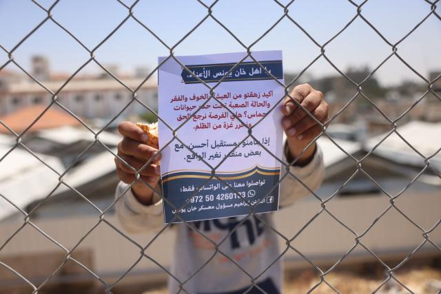 A young displaced Palestinian holds a leaflet that was dropped by the Israeli army, in Khan Yunis in the southern Gaza Strip on April 30, 2026. The majority of Gaza's 2.4 million people have been displaced, often multiple times, by the war that began with Hamas's attack on southern Israel on October 7, 2023. With displaced families living in tented camps, with serious concerns raised about their living conditions. (Photo by Bashar Taleb / AFP)