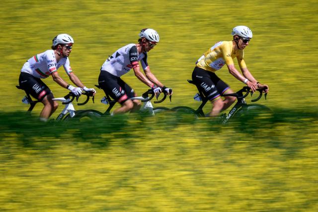 (From L) UAE Team Emirates XRG’s Portuguese rider Ivo Oliveira, UAE Team Emirates-XRG's Austrian rider Felix Grossschartner and UAE Team Emirates-XRG's Slovenian rider Tadej Pogacar ride next to rapeseed fields during the second stage of the Tour of Romandie UCI cycling World tour, 173.1 km from Rue to Vucherens, near Vulliens, on April 30, 2026.  (Photo by Fabrice COFFRINI / AFP)