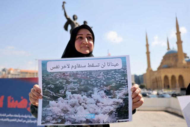 A residents of the devastated southern Lebanese border villages holds a placards as they protest against the destruction of their villages and being prevented from returning by order of the Israeli army, at Martyrs Square in central Beirut on April 30, 2026. On April 30, an Israeli army spokesperson called for the evacuation of eight southern villages ahead of planned military action there. Shortly after the ceasefire began on April 17, Israel declared a so-called "Yellow Line", a strip of Lebanese territory about 10 kilometres deep along the border, where it has been operating and demolishing villages. (Photo by Anwar AMRO / AFP)