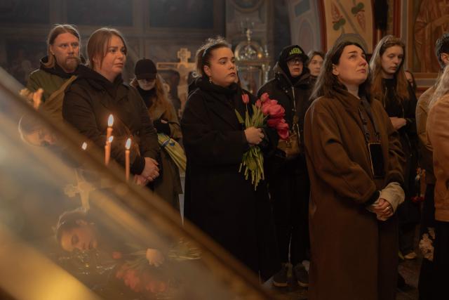 Relatives, friends, and other attendees mourn over the coffin of Viktoria 'Kvitka' Bobrova, callsign "Flower", a Ukrainian producer and military member of the 10th Mountain Assault Brigade "Edelweiss", who was killed in eastern Ukraine, during her funeral ceremony at Saint Michael's Golden-Domed Monastery in Kyiv on April 30, 2026, amid the Russian invasion of Ukraine. (Photo by Roman PILIPEY / AFP)