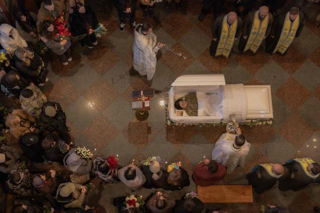 Relatives, friends, and other attendees mourn over the coffin of Viktoria 'Kvitka' Bobrova, callsign "Flower", a Ukrainian producer and military member of the 10th Mountain Assault Brigade "Edelweiss", who was killed in eastern Ukraine, during her funeral ceremony at Saint Michael's Golden-Domed Monastery in Kyiv on April 30, 2026, amid the Russian invasion of Ukraine. (Photo by Roman PILIPEY / AFP)