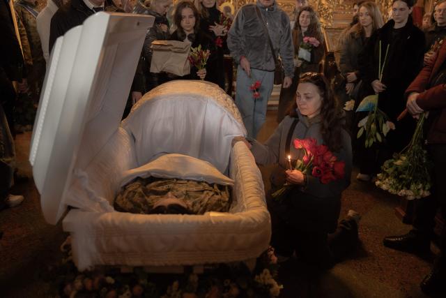 A woman mourns over the coffin of Viktoria 'Kvitka' Bobrova, callsign "Flower", a Ukrainian producer and military member of the 10th Mountain Assault Brigade "Edelweiss", who was killed in eastern Ukraine, during her funeral ceremony at Saint Michael's Golden-Domed Monastery in Kyiv on April 30, 2026, amid the Russian invasion of Ukraine. (Photo by Roman PILIPEY / AFP)