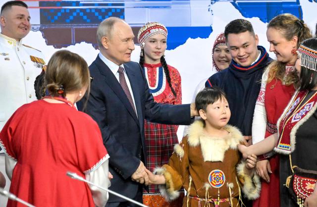 In this pool photograph distributed by the Russian state agency Sputnik, Russia's President Vladimir Putin (C-L)) meets with representatives of Russia's indigenous minorities as part of the educational marathon in Moscow on April 30, 2026. (Photo by Viacheslav PROKOFIEV / POOL / AFP)