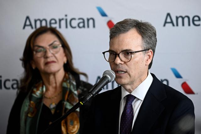 Head of the US diplomatic mission in Venezuela John Barrett speaks beside Venezuela’s Transport Minister Jacqueline Faria during a press conference at Simon Bolivar International Airport in La Guaira, La Guaira state, Venezuela, ahead of the arrival of a flight from Miami on April 30, 2026. The first direct flight between the United States and Venezuela in seven years took off on April 30, a new sign of a thaw after Washington deposed leftist leader Nicolas Maduro. (Photo by Federico PARRA / AFP)