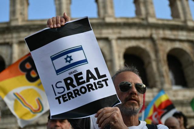 A protester holds a placard during a rally in support of the Freedom Flotilla in front of the Colosseum in Rome on April 30, 2020. The Israeli navy intercepted and halted part of the Global Sumud Flotilla, a convoy of vessels bound for Gaza as it sailed in international waters west of the island of Crete. According to Israeli sources and flotilla organizers, at least twenty boats were boarded and around 175 activists were detained and transferred to Israel. (Photo by Alberto PIZZOLI / AFP)