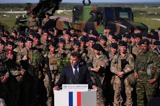 France's President Emmanuel Macron (C) speaks with soldiers during the Orion 2026 military exercises in Suippes, eastern France on April 30, 2026. Troops are being deployed as part of Orion 26, a large-scale exercise launched in February which, in its fourth and final phase, currently involves up to 12,500 military personnel. (Photo by Aurelien Morissard / POOL / AFP)
