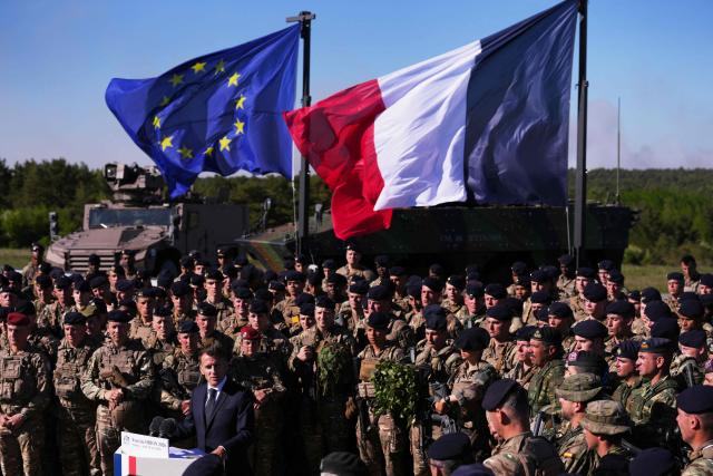 France's President Emmanuel Macron (C) speaks with soldiers during the Orion 2026 military exercises in Suippes, eastern France on April 30, 2026. Troops are being deployed as part of Orion 26, a large-scale exercise launched in February which, in its fourth and final phase, currently involves up to 12,500 military personnel. (Photo by Aurelien Morissard / POOL / AFP)