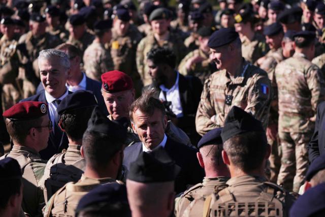 France's President Emmanuel Macron (C) speaks with soldiers during the Orion 2026 military exercises in Suippes, eastern France on April 30, 2026. Troops are being deployed as part of Orion 26, a large-scale exercise launched in February which, in its fourth and final phase, currently involves up to 12,500 military personnel. (Photo by Aurelien Morissard / POOL / AFP)