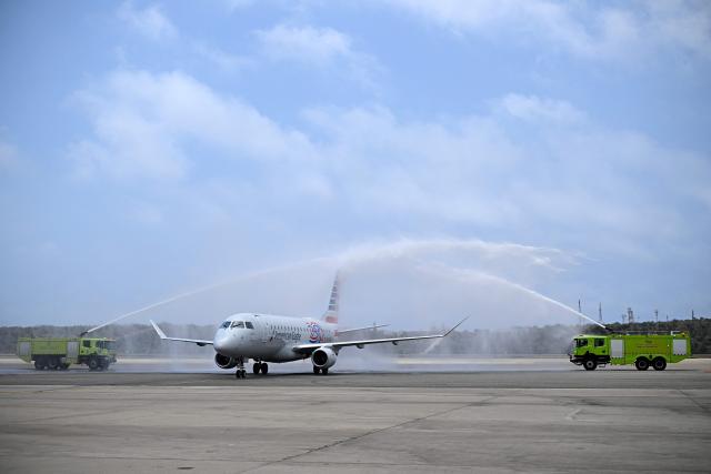 An American Eagle aircraft, operating a regional flight for American Airlines, is sprayed with water after landing at Simon Bolivar International Airport in La Guaira, La Guaira state, Venezuela on April 30, 2026. The first direct commercial flight between the United States and Venezuela in seven years arrived in Caracas on April 30, marking a new sign of a thaw after Washington deposed leftist leader Nicolas Maduro and resumed diplomatic relations following years of tension. (Photo by Federico PARRA / AFP)