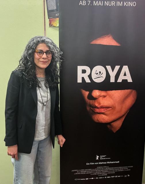Iranian film director Mahnaz Mohammadi poses next to the poster of her film "Roya" on April 29, 2026 at a cinema in Berlin, before the preview screening of the movie, during an interview with AFP. Already shown at the Berlinale film festival 2026 in the Panorama section in February, the film will be released in German cinemas on May 7, 2026. The film crew of "Roya," that is about the traumas endured by a political prisoner in Evin Prison in Tehran, called on audiences at the film’s German premiere to “not forget” the Iranian people. “The existence of the Iranian people today is like that of Roya,” the film’s heroine, “it’s not livable,” director Mahnaz Mohammadi, 51, summed up in an interview with AFP. (Photo by Pierrick YVON / AFP)