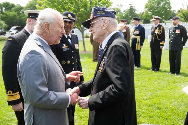 Britain's King Charles III shakes hands with a veteran military member after laying a wreath at the tomb of the unknown soldier in Arlington National Cemetery in Arlington, Virginia, on April 30, 2026. King Charles III and Queen Camilla visited the Canadian Cross of Sacrifice, dedicated to those US citizens who volunteered for the Canadian Expeditionary Force (CEF) and lost their lives in the First World War. (Photo by SAUL LOEB / POOL / AFP)