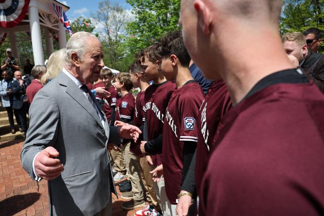Britain's King Charles and Queen Camilla greet the Virginia state champions Front Royal Little League baseball team as they arrive for a parade and block party in Front Royal, Virginia, on April 30, 2026. (Photo by Win McNamee / POOL / AFP)
