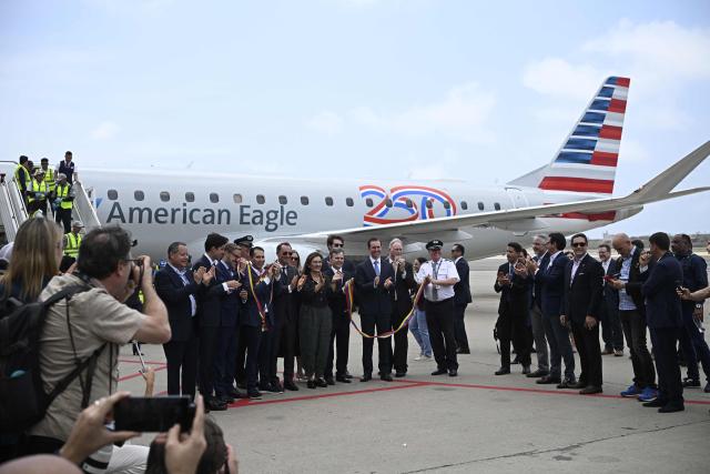 A ribbon in the colors of the Venezuelan flag is cut following the arrival of an American Eagle, operating a regional flight for American Airlines, aircraft at Simon Bolivar International Airport in La Guaira, La Guaira state, Venezuela on April 30, 2026. The first direct commercial flight between the United States and Venezuela in seven years arrived in Caracas on April 30, marking a new sign of a thaw after Washington deposed leftist leader Nicolas Maduro and resumed diplomatic relations following years of tension. (Photo by Federico PARRA / AFP)