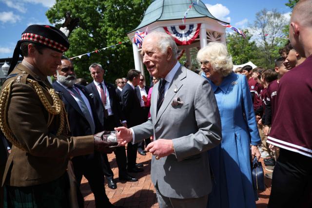 King Charles III hands off a gifted baseball as he and Queen Camilla greet the Virginia state champions Front Royal Little League baseball team during a parade and block party event on the final day of the state visit of King Charles III and Queen Camilla on April 30, 2026 in Front Royal, Virginia. (Photo by Win McNamee / POOL / AFP)