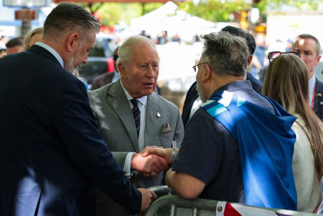 Britain's King Charles shakes hands with a community member during block party on April 30, 2026 in Front Royal, Virginia. (Photo by Kylie Cooper / POOL / AFP)