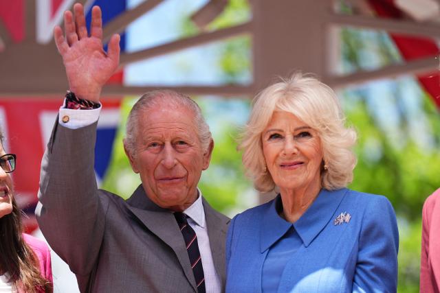 Britain's King Charles waves next to Queen Camilla during a parade and block party in Front Royal, Virginia, on April 30, 2026. (Photo by Aaron Chown / POOL / AFP)