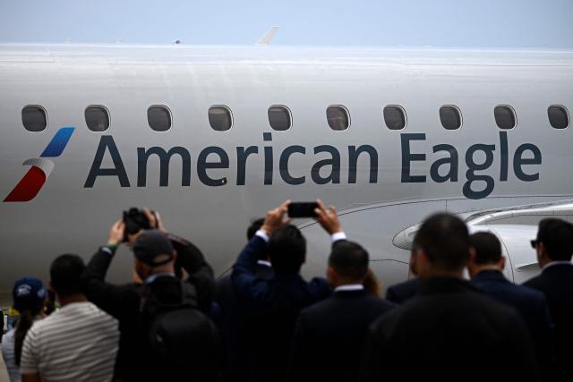 People take pictures of an American Eagle aircraft, operating a regional flight for American Airlines, after landing at Simon Bolivar International Airport in La Guaira, La Guaira state, Venezuela on April 30, 2026. The first direct commercial flight between the United States and Venezuela in seven years arrived in Caracas on April 30, marking a new sign of a thaw after Washington deposed leftist leader Nicolas Maduro and resumed diplomatic relations following years of tension. (Photo by Federico PARRA / AFP)