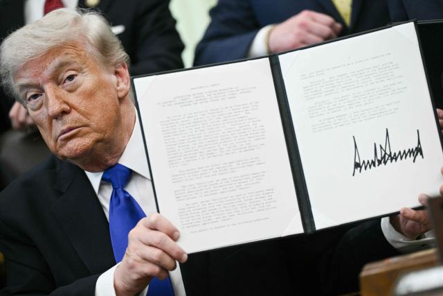 US President Donald Trump holds a signed executive order in the Oval Office at the White House in Washington, DC on April 30, 2026. (Photo by Brendan SMIALOWSKI / AFP)