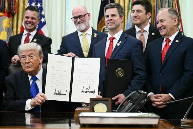 US President Donald Trump holds a signed executive order appointing Dr. Nicole Saphier as the new Surgeon General in the Oval Office at the White House in Washington, DC on April 30, 2026. (Photo by Brendan SMIALOWSKI / AFP)