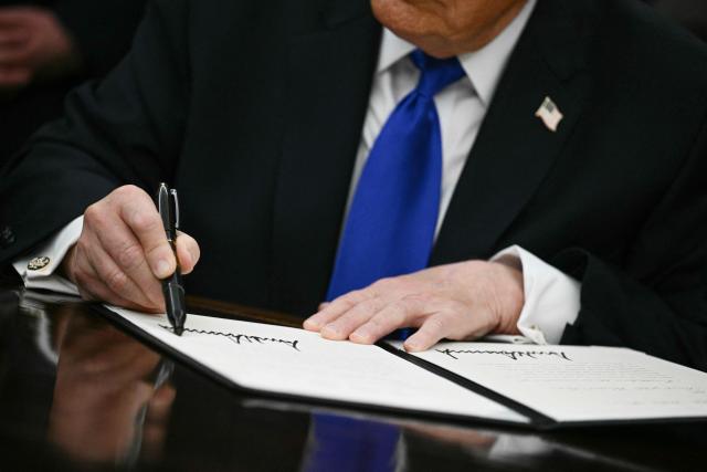 US President Donald Trump signs an executive order in the Oval Office at the White House in Washington, DC on April 30, 2026. (Photo by Brendan SMIALOWSKI / AFP)