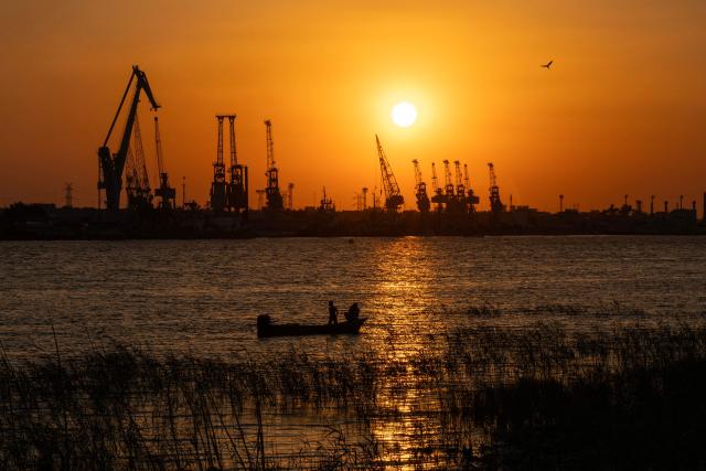 A fishing boat sails along the Shatt al-Arab river during sunset near the abandoned Maqal commercial port in the southern Iraqi city of Basra on April 30, 2026. (Photo by Hussein FALEH / AFP)