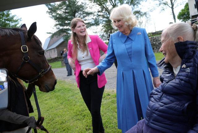 Britain's Queen Camilla Smitten (R), Farm manager Hunter Marek (L) and Smitten Farm owner Ann Mudge Backer look at a horse at Smitten Farm in The Plains, Virginia, on April 30, 2026. (Photo by Kevin Dietsch / POOL / AFP)