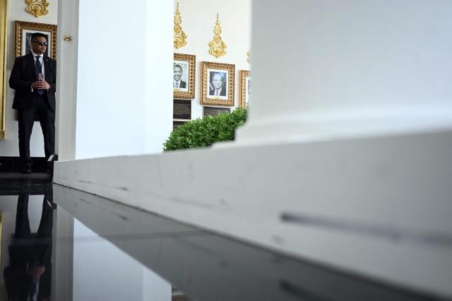 A US Secret Service agent stands guard by the newly installed black granite flooring in The West Wing Colonnade of the White House in Washington, DC on April 30, 2026. (Photo by Brendan SMIALOWSKI / AFP)