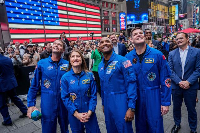 (L/R) Artemis II Commander Reid Wiseman, Artemis II mission specialist Christina Koch, Artemis II pilot Victor Glover and Artemis II mission specialist Jeremy Hansen look at the Nasdaq MarketSite in Times Square in New York City on April 30, 2026.


A photo of the moon is seen on a screen as The New York Stock Exchange welcomed NASA to the podium in celebration of the historic Artemis II mission in New York on April 30, 2026. (Photo by Adam GRAY / AFP)