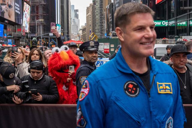 A street performer dressed as Elmo takes photographs of Artemis II mission specialist Jeremy Hansen outside of the Nasdaq MarketSite in Times Square in New York City on April 30, 2026. (Photo by Adam GRAY / AFP)