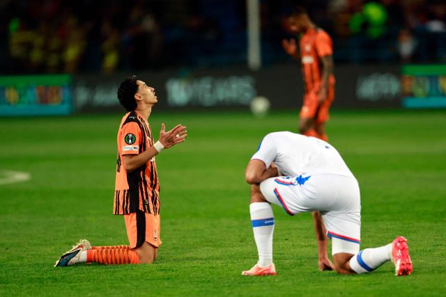 Shakhtar Donetsk's Brazilian midfielder #14 Isaque (L) kneels next to a Crystal Palace player after the UEFA Conference League semi-final first leg football match between FC Shakhtar Donetsk and Crystal Palace FC in Krakow, Poland on April 30, 2026. Crystal Palace won the match 3-1. (Photo by Wojtek RADWANSKI / AFP)