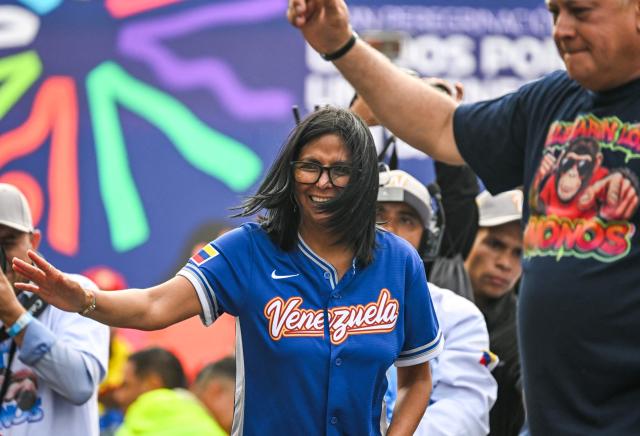 Venezuela's acting president Delcy Rodriguez gestures next to Venezuela's Interior Minister Diosdado Cabello (R) during a march calling for the lifting of all US sanctions in Caracas on April 30, 2026. Delcy Rodriguez announced on April 30 a 26% wage increase to the so-called "integral minimum income," raising it from 190 dollars to 240 dollars per month, the first adjustment since Nicolas Maduro's fall. (Photo by Juan BARRETO / AFP)