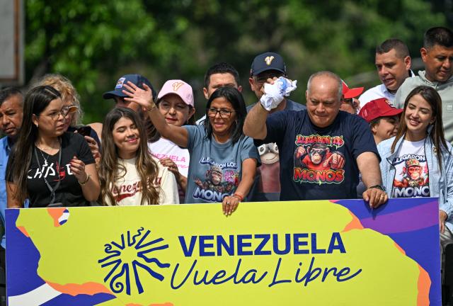 Venezuela's acting president Delcy Rodriguez (C) gestures next to Interior Minister Diosdado Cabello (2nd R) during a march calling for the lifting of all US sanctions in Caracas on April 30, 2026. Delcy Rodriguez announced on April 30 a 26% wage increase to the so-called "integral minimum income," raising it from 190 dollars to 240 dollars per month, the first adjustment since Nicolas Maduro's fall. (Photo by Juan BARRETO / AFP)