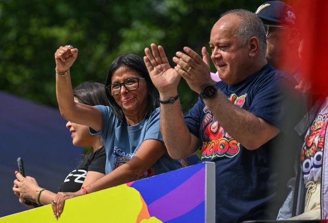 Venezuela's acting president Delcy Rodriguez gestures next to Interior Minister Diosdado Cabello (R) during a march calling for the lifting of all US sanctions in Caracas on April 30, 2026. Delcy Rodriguez announced on April 30 a 26% wage increase to the so-called "integral minimum income," raising it from 190 dollars to 240 dollars per month, the first adjustment since Nicolas Maduro's fall. (Photo by Juan BARRETO / AFP)