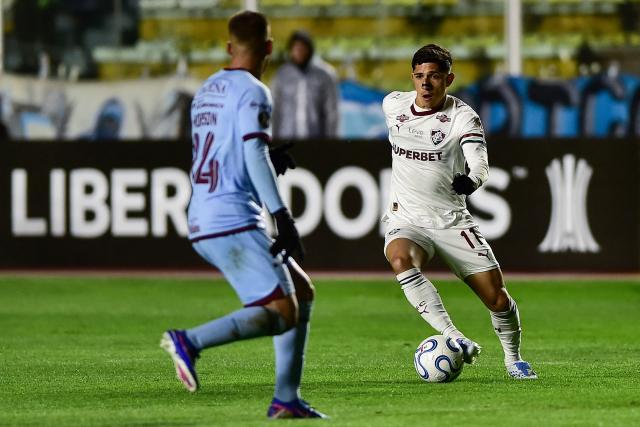 Fluminense's Venezuelan forward #11 Jefferson Savarino runs with the ball past Bolivar's midfielder #14 Robson Matheus during the Copa Libertadores group stage football match between Bolivia's Bolivar and Brazil's Fluminense at the Hernando Siles stadium in La Paz on April 30, 2026. (Photo by Jorge BERNAL / AFP)