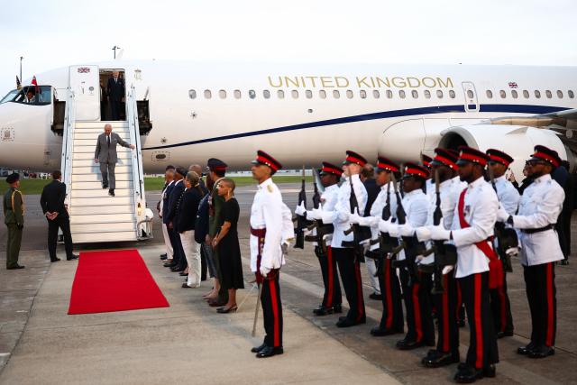 Members of the Royal Bermuda Regiment stand in attention as Britain's King Charles III steps off his plane upon arrival to the L.F. Wade International Airport in Hamilton, Bermuda, on April 30, 2026. King Charles III is in Bermuda for his first visit to a British Overseas Territory as Sovereign. (Photo by HENRY NICHOLLS / AFP)