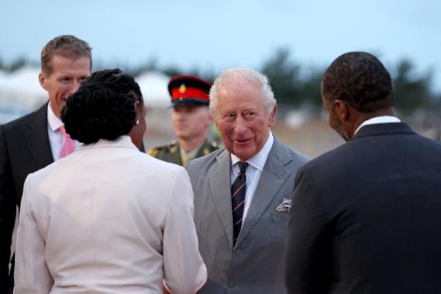 Britain's King Charles III is welcomed by officials, including Governor of Bermuda Andrew Murdoch (L), upon arrival at L.F. Wade International Airport in Hamilton, Bermuda, on April 30, 2026. King Charles III is in Bermuda for his first visit to a British Overseas Territory as Sovereign. (Photo by Chris Jackson / POOL / AFP)