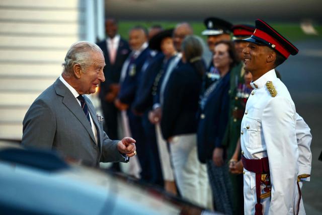 Britain's King Charles III speaks with a member of the Royal Bermuda Regiment after arriving to the L.F. Wade International Airport in Hamilton, Bermuda, on April 30, 2026. King Charles III is in Bermuda for his first visit to a British Overseas Territory as Sovereign. (Photo by Henry NICHOLLS / AFP)