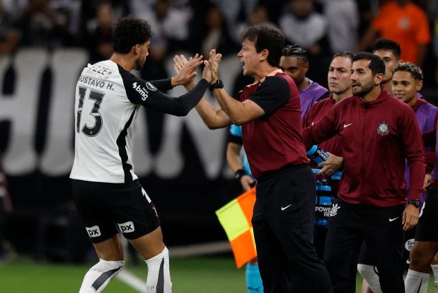 Corinthians' defender #13 Gustavo Henrique celebrates with head coach Fernando Diniz after scoring his team's first goal during the Copa Libertadores group stage football match between Brazil's Corinthians and Uruguay's Penarol at the Neo Quimica Arena stadium in Sao Paulo, Brazil on April 30, 2026. (Photo by Miguel SCHINCARIOL / AFP)