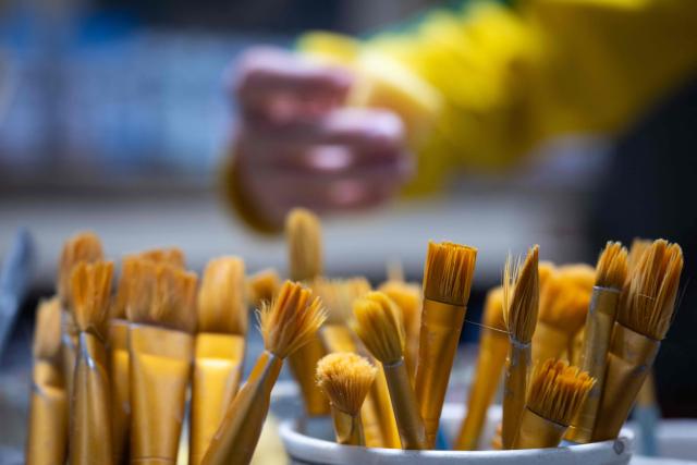 This photograph shows brushes in a pot during a workshop in a "Cafe ceramique" in Strasbourg, eastern France on April 21, 2026. People come here to switch off from everyday life and their screens, painting a vase or a plate whilst sipping a latte macchiato: riding the wave of the ‘handmade’ trend, ‘ceramics cafes’ are popping up all over France. (Photo by SEBASTIEN BOZON / AFP)