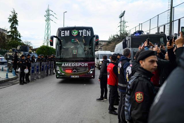 Amedspor's team bus passes through a security corridor as they arrive for the Trendyol League football match between Amedspor and Esenler Erokspor at the Esenler Erokspor Stadium, in the Esenler district of Istanbul, on April 9, 2026. Amedspor, a club from Diyarbakir, the "capital" of Turkey's predominantly Kurdish southeast, can secure promotion to the first division on May 2, 2026, an unprecedented prospect that has sparked a wave of enthusiasm among the country's millions of Kurds. (Photo by Yasin AKGUL / AFP)